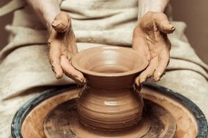Close up of female hands working on potters wheel