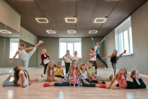 Keep dancing. Group of happy little boys and girls in fashionable clothes posing together in the dance studio. Dance team. Hip hop